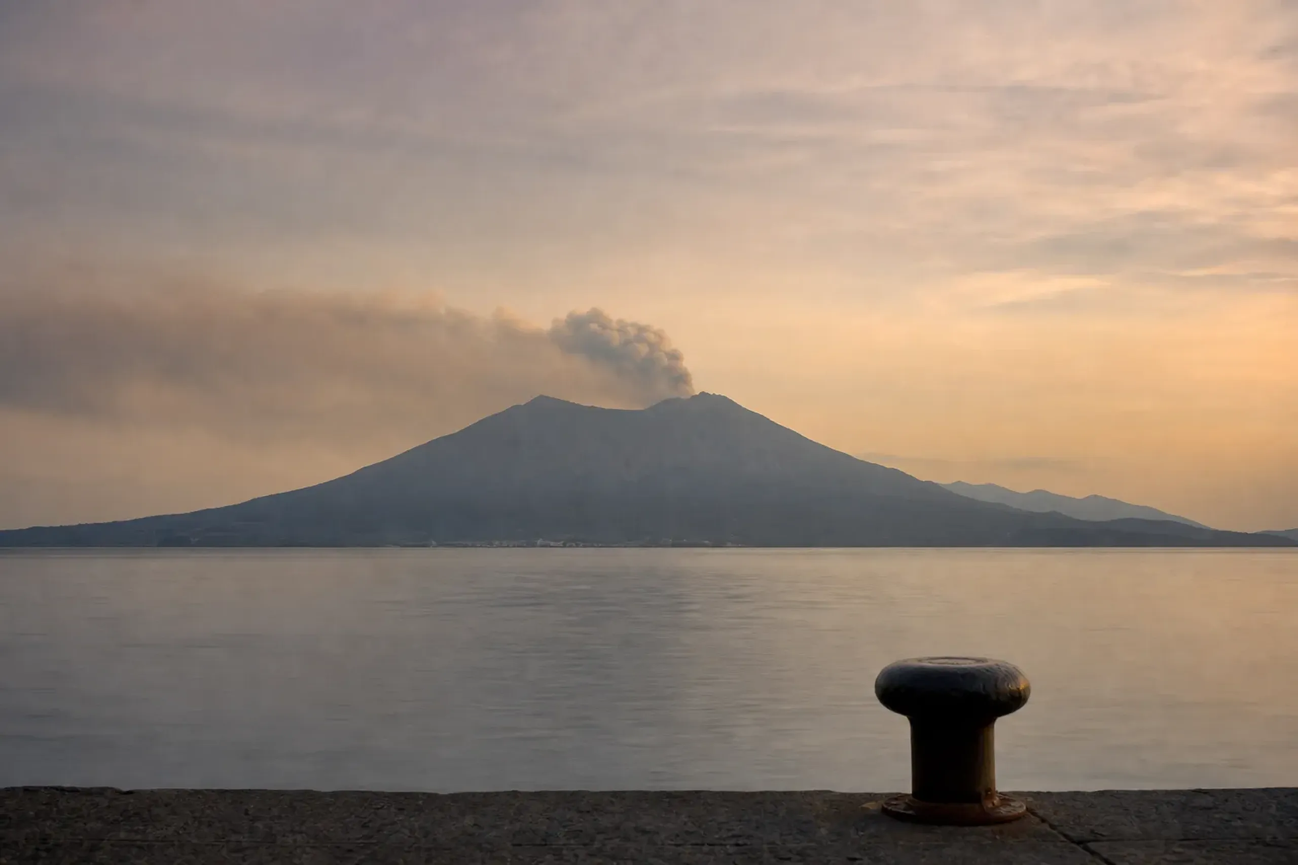 Sakurajima volcano puffing ash across Kinko Bay as seen from the Kagoshima waterfront at the southern tip of Kyushu