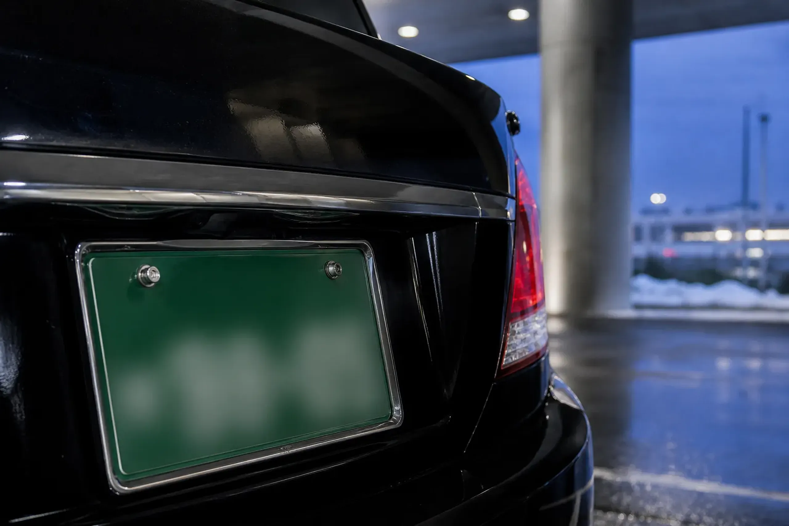 Green Japanese license plate on a commercial passenger vehicle with numbers blurred