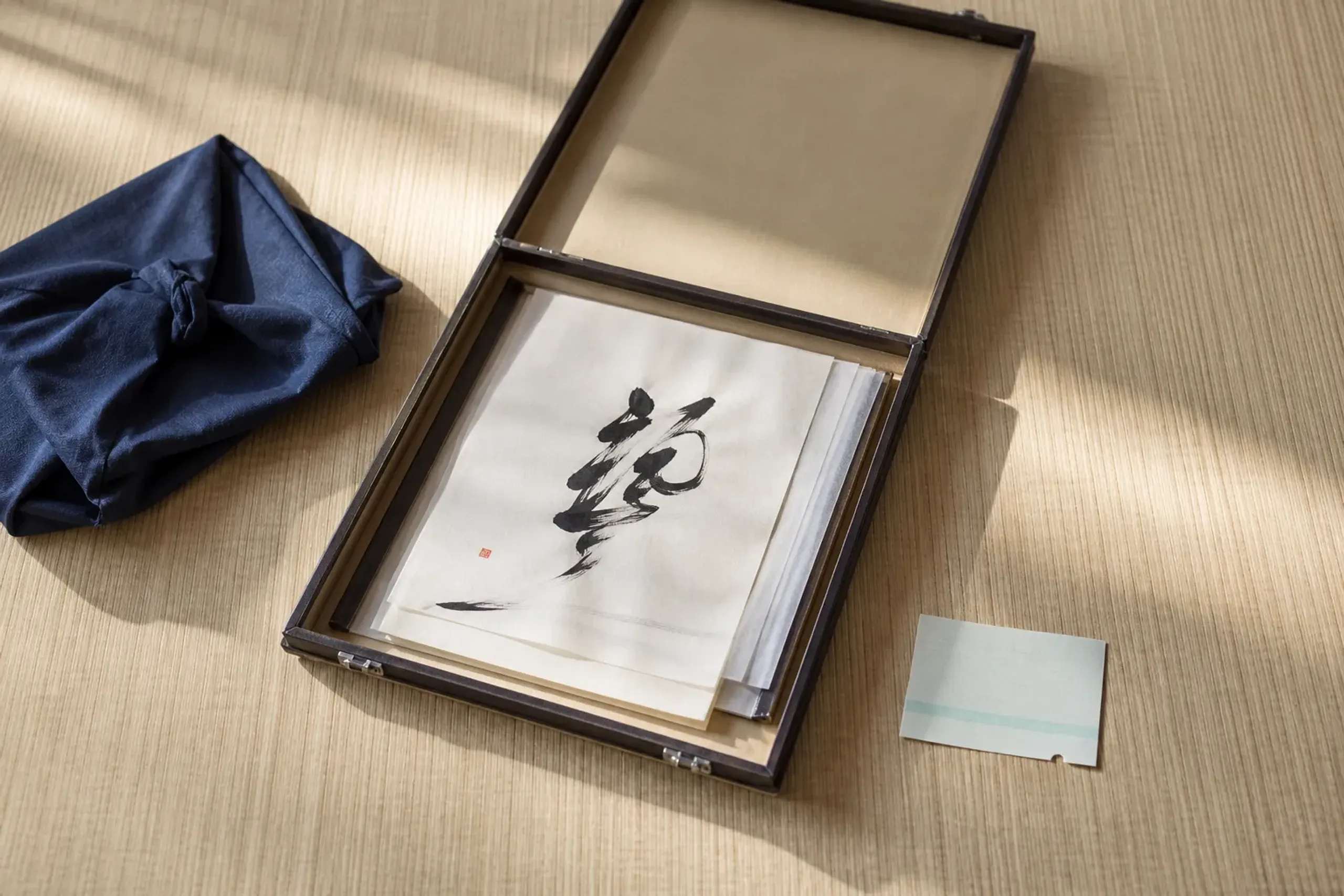 Calligraphy sheets packed flat in a rigid portfolio for travel