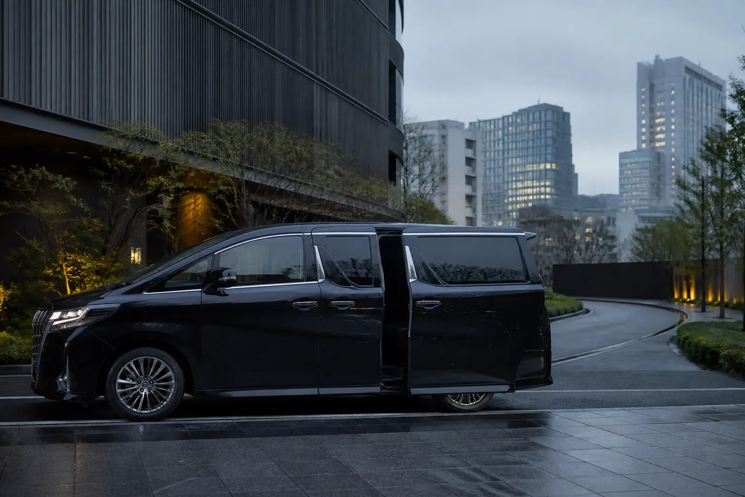 Black luxury minivan arriving at a quiet Tokyo hotel driveway early morning with no people visible
