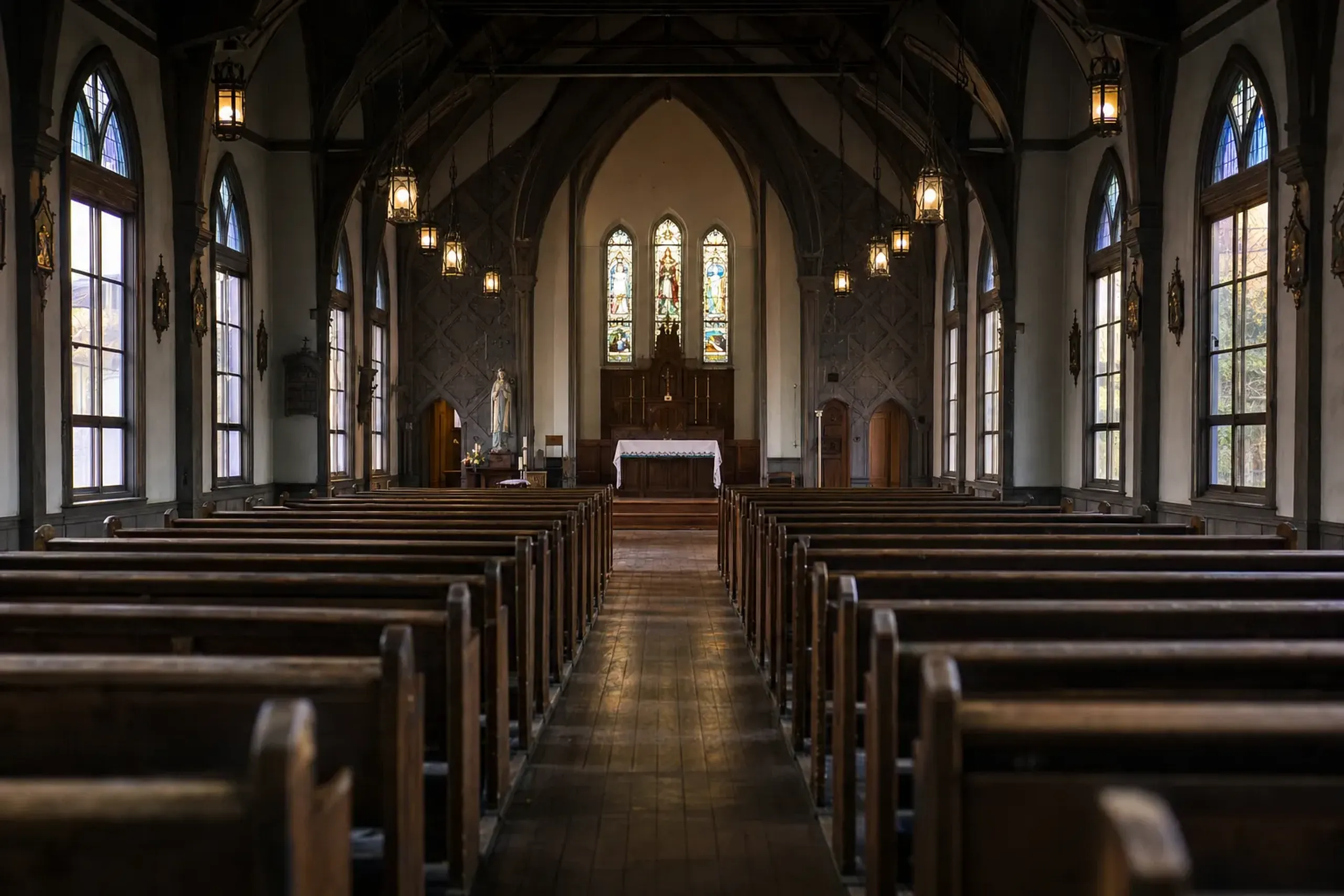 The quiet interior wooden nave and pews of Egami Church on Naru Island, empty and sunlit, highlighting its noted authenticity