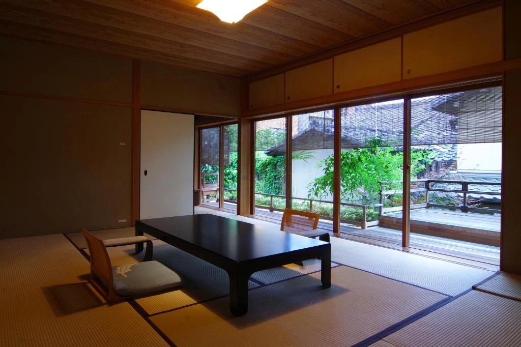 Traditional wooden entrance of a Kyoto ryokan on a calm street in Nakagyo Ward
