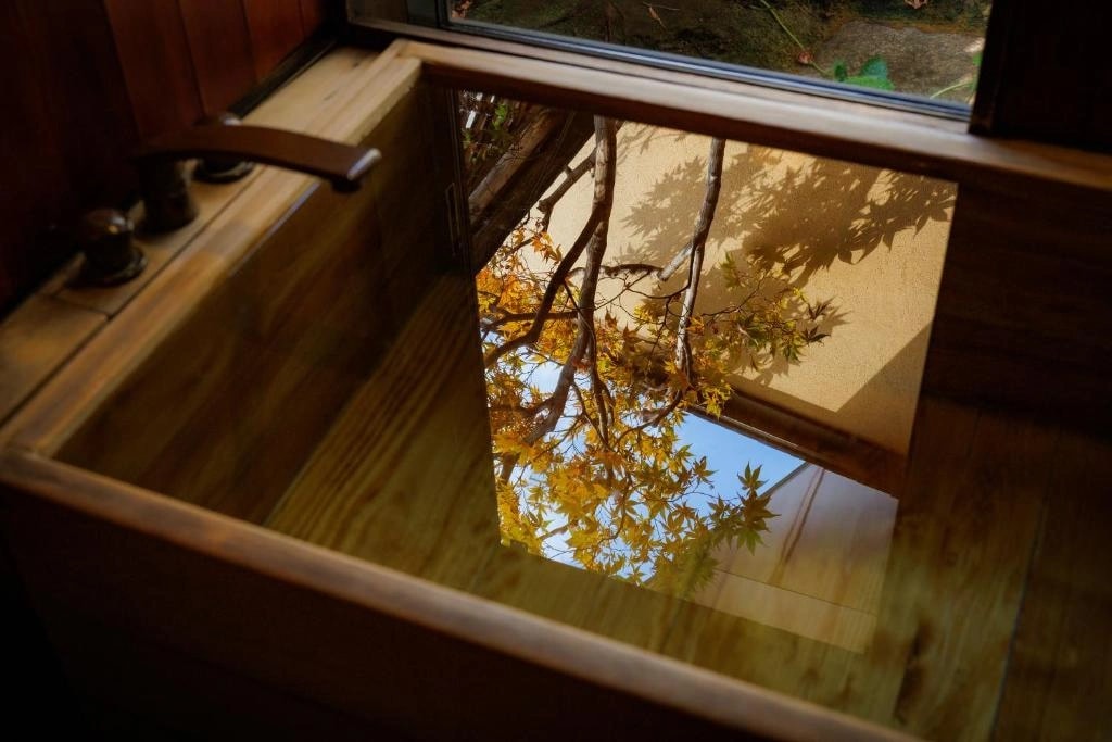 Wooden kōyamaki bath tub with stained glass detail in a private family bath at a Kyoto ryokan