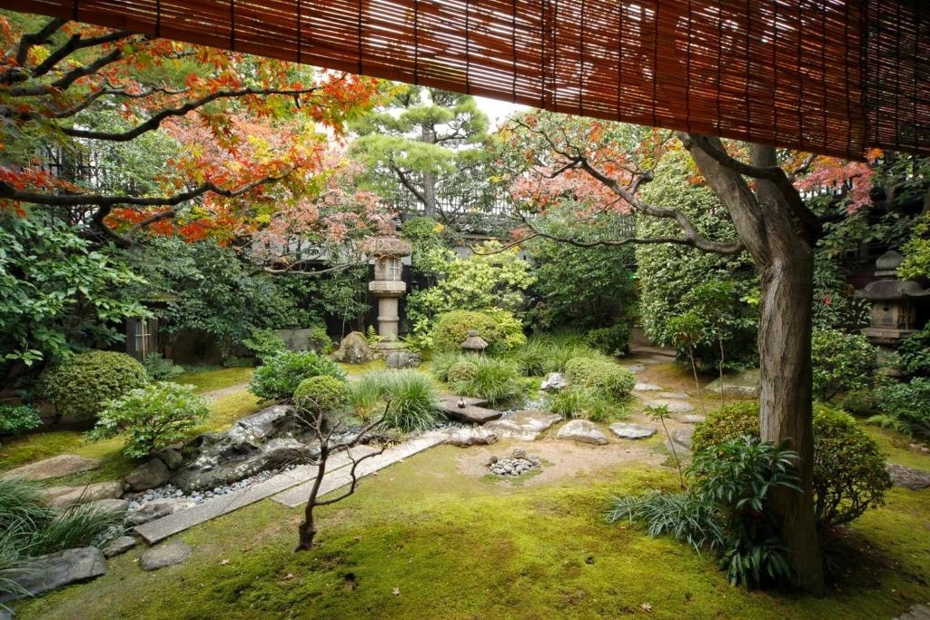 Tatami room with shoji screens facing a small tsuboniwa courtyard garden in Kyoto