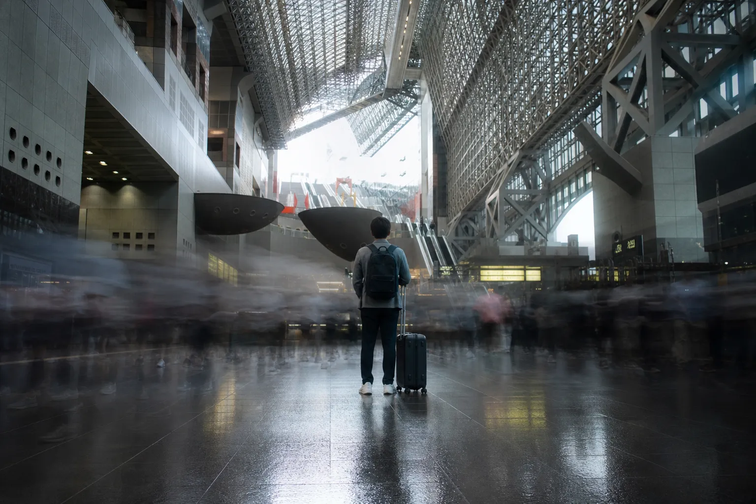 A sophisticated long-exposure photograph capturing the dynamic motion of commuters at Kyoto Station, where blurred figures signify the intense energy and volume of morning peak travel times.