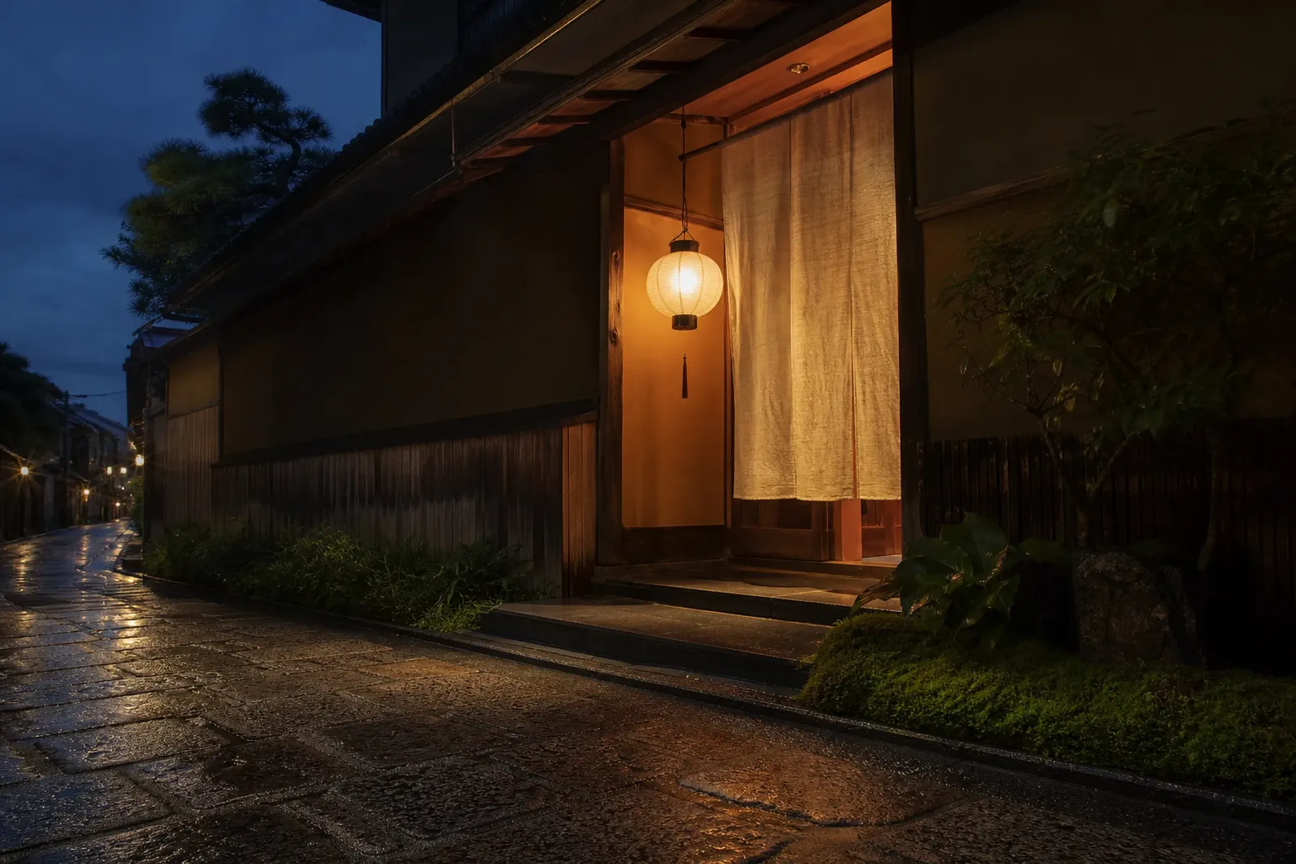 Understated Kyoto luxury hotel entrance on a quiet street at dusk