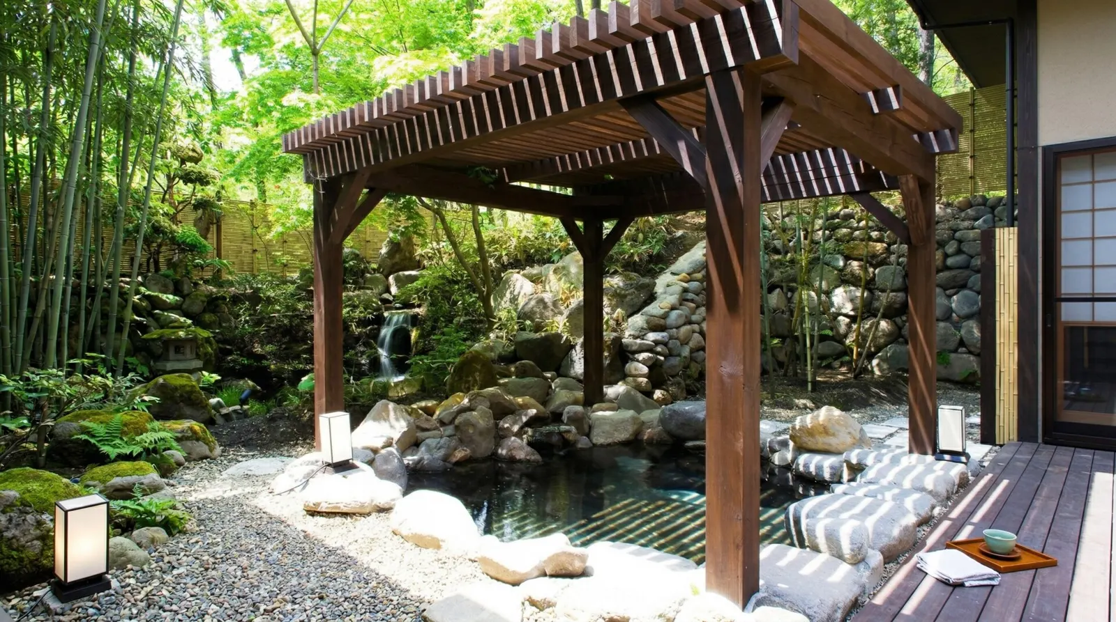 A luxurious outdoor private hot spring bath made of wood and stone attached to the Presidential Suite at Chikusenso.