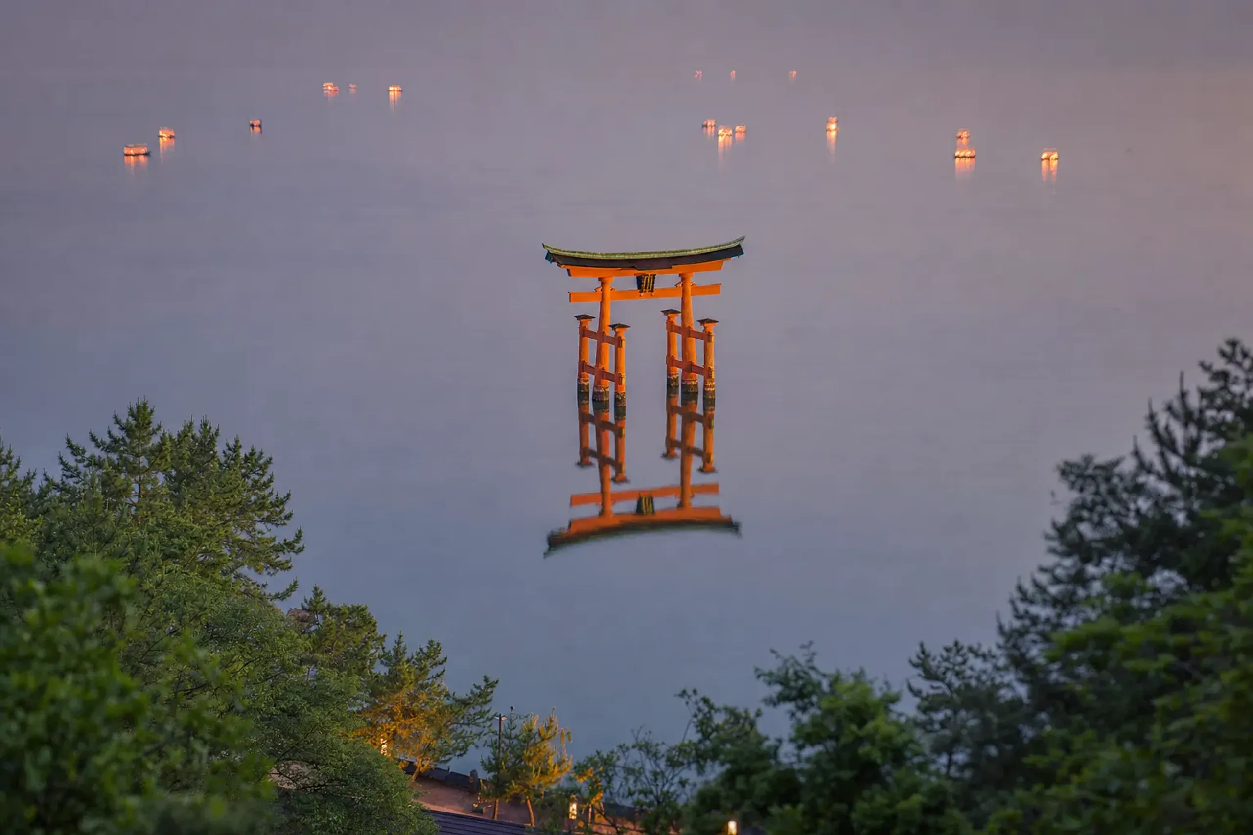 the 16-metre-tall vermilion Great Torii of Itsukushima Shrine, its camphor-wood pillars mirrored in the high tidal water of the Seto Inland Sea