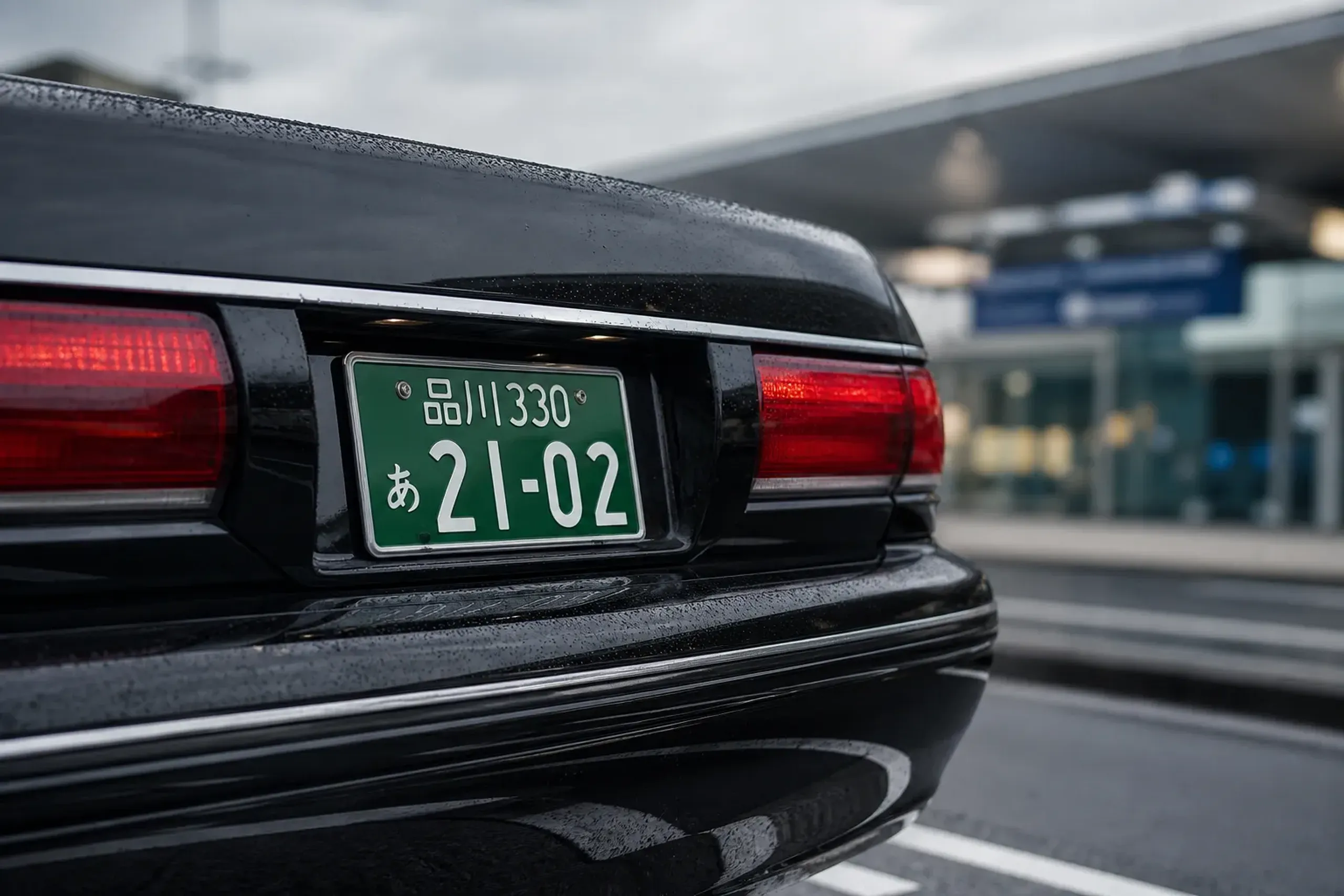 Green license plate on a commercial passenger vehicle in Japan, illustrating legal private hire licensing