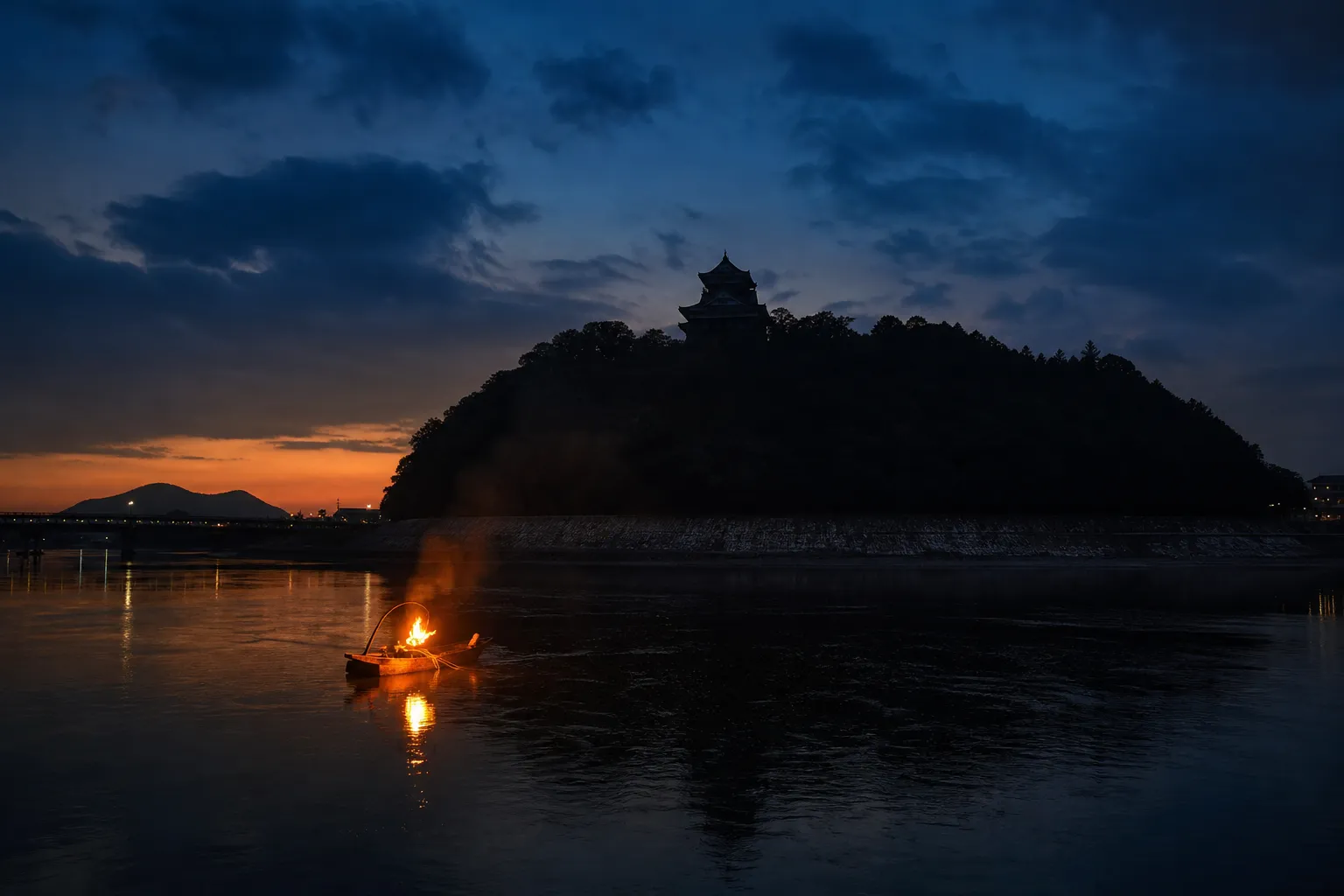 Inuyama Castle behind the Kiso River at night with a lit boat on the water