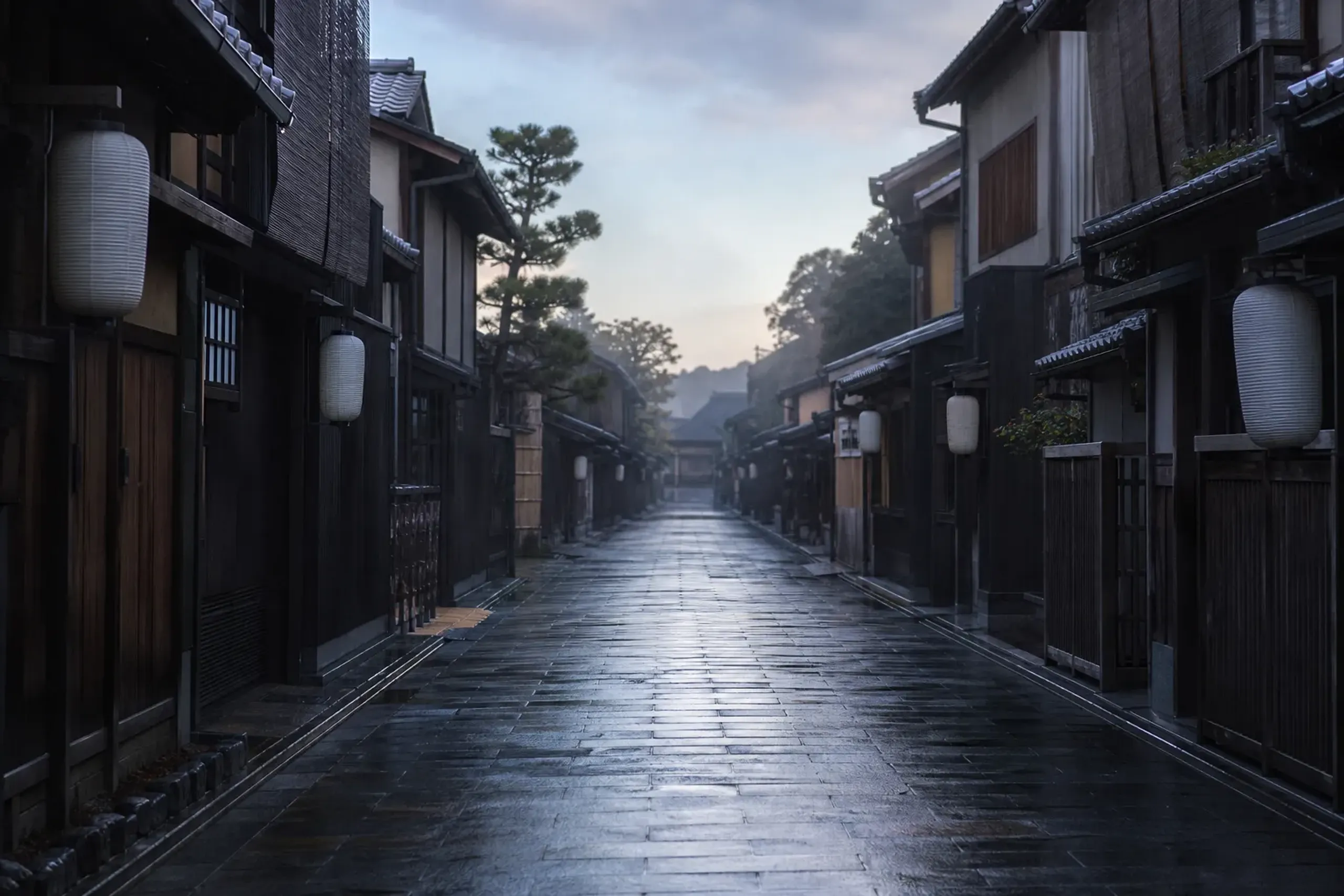 Empty traditional stone-paved lane in Kyoto in early morning with wooden townhouses
