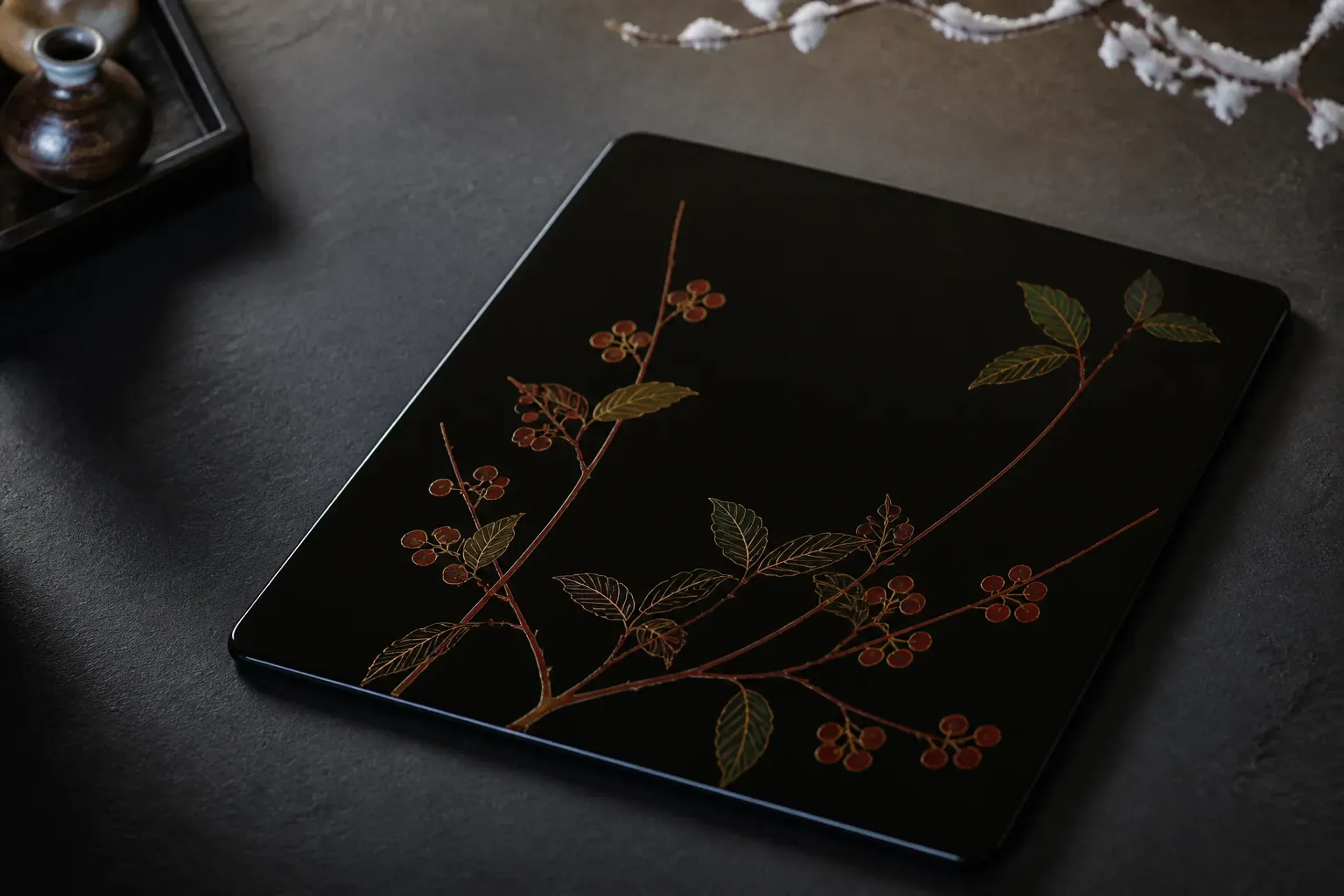 A finished Kinma-technique lacquer panel showing coloured designs incised with a curved blade and polished flush into the cured black urushi surface