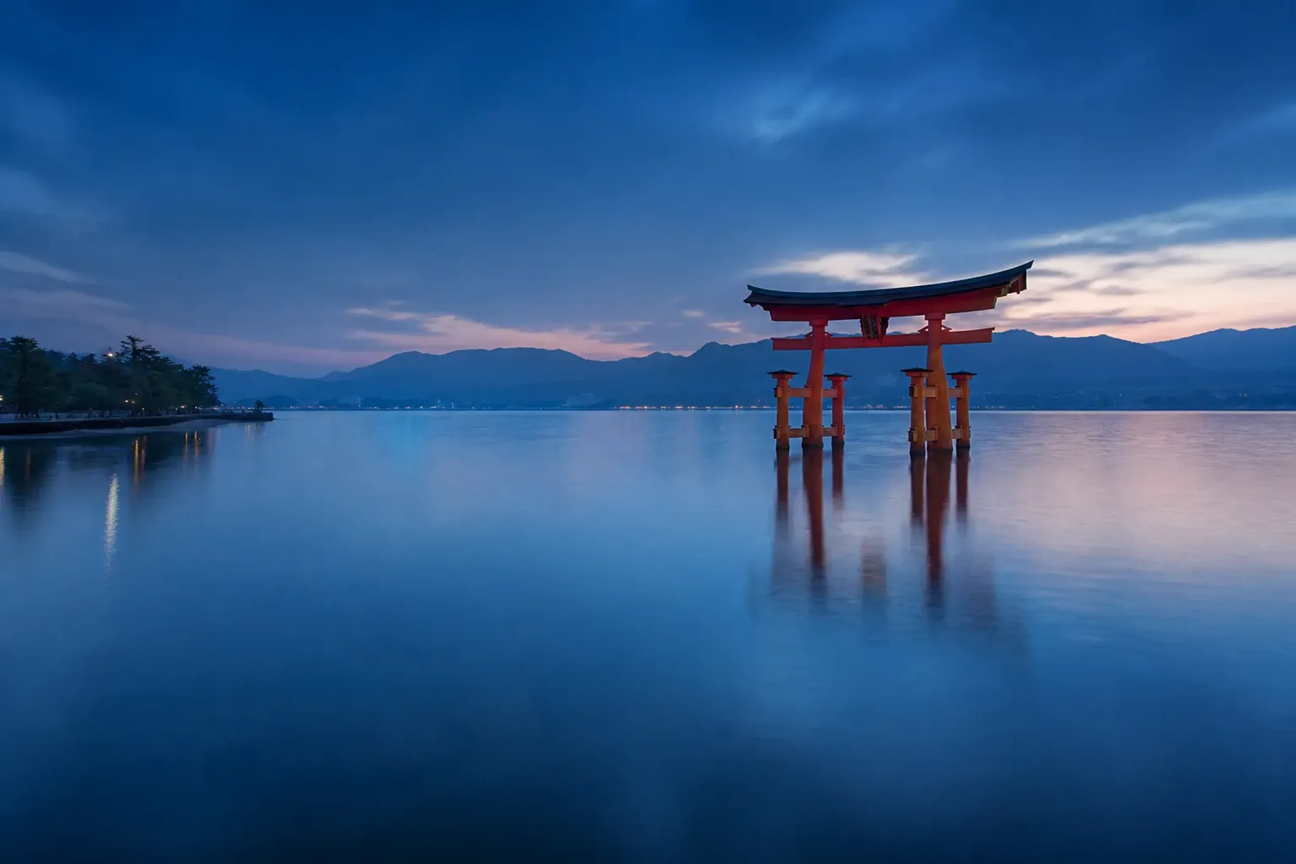 The vermilion floating torii gate of Itsukushima Shrine at Miyajima rising from the tidal waters of Hiroshima Bay