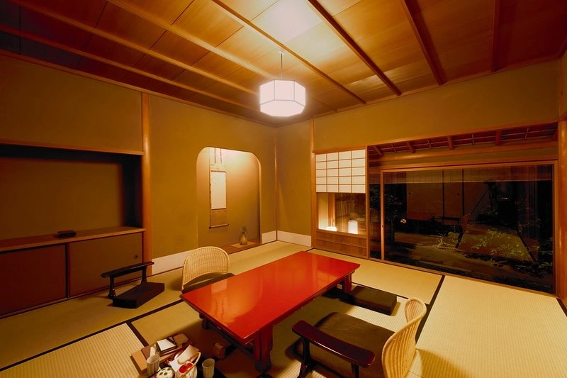Tatami room view looking onto a mossy Kyoto garden with stones and shrubs