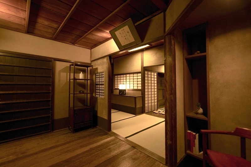 a tatami guest room at Tawaraya facing its interior moss-and-stone garden, with folded futon bedding and a low lacquered table catching soft morning light
