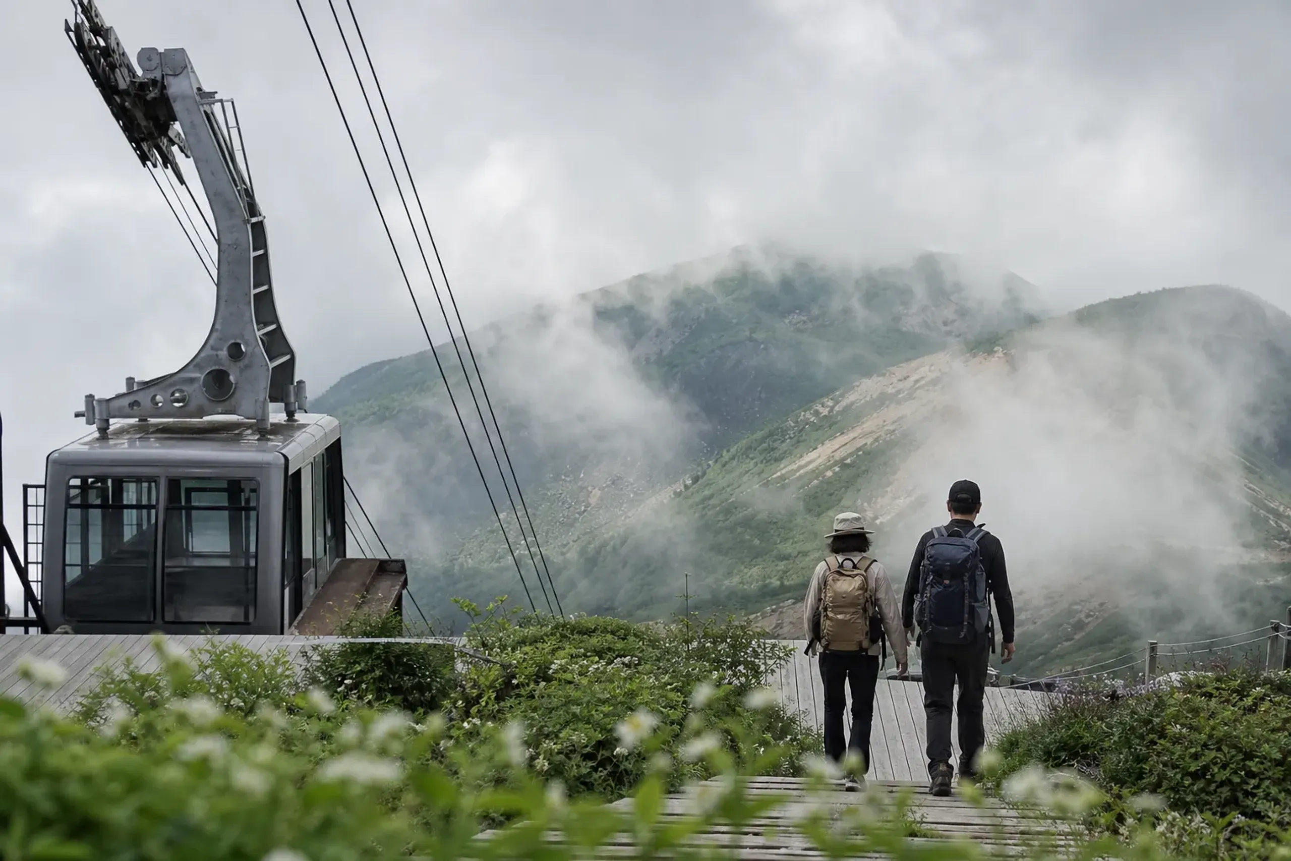 Hikers near Asahidake Ropeway in Daisetsuzan National Park with alpine terrain and clouds