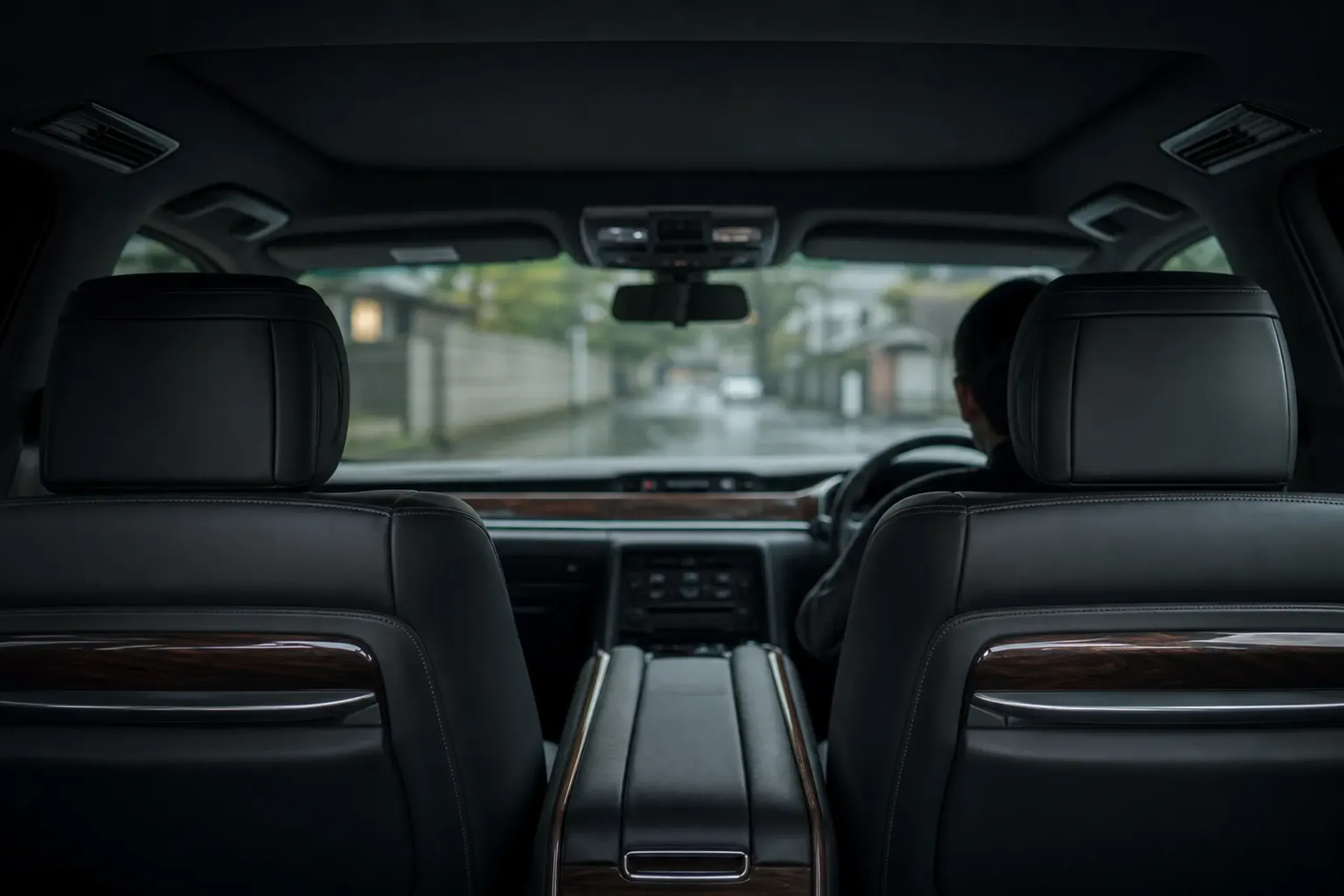 Spacious chauffeured vehicle interior with soft light and a calm view through tinted windows