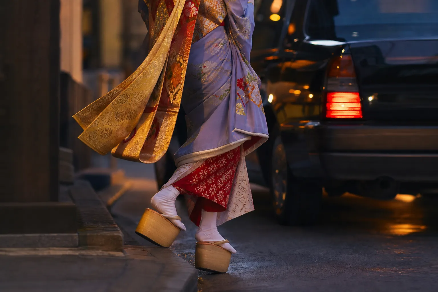 Close-up of a maiko kimono and obi beside a modern taxi in Japan