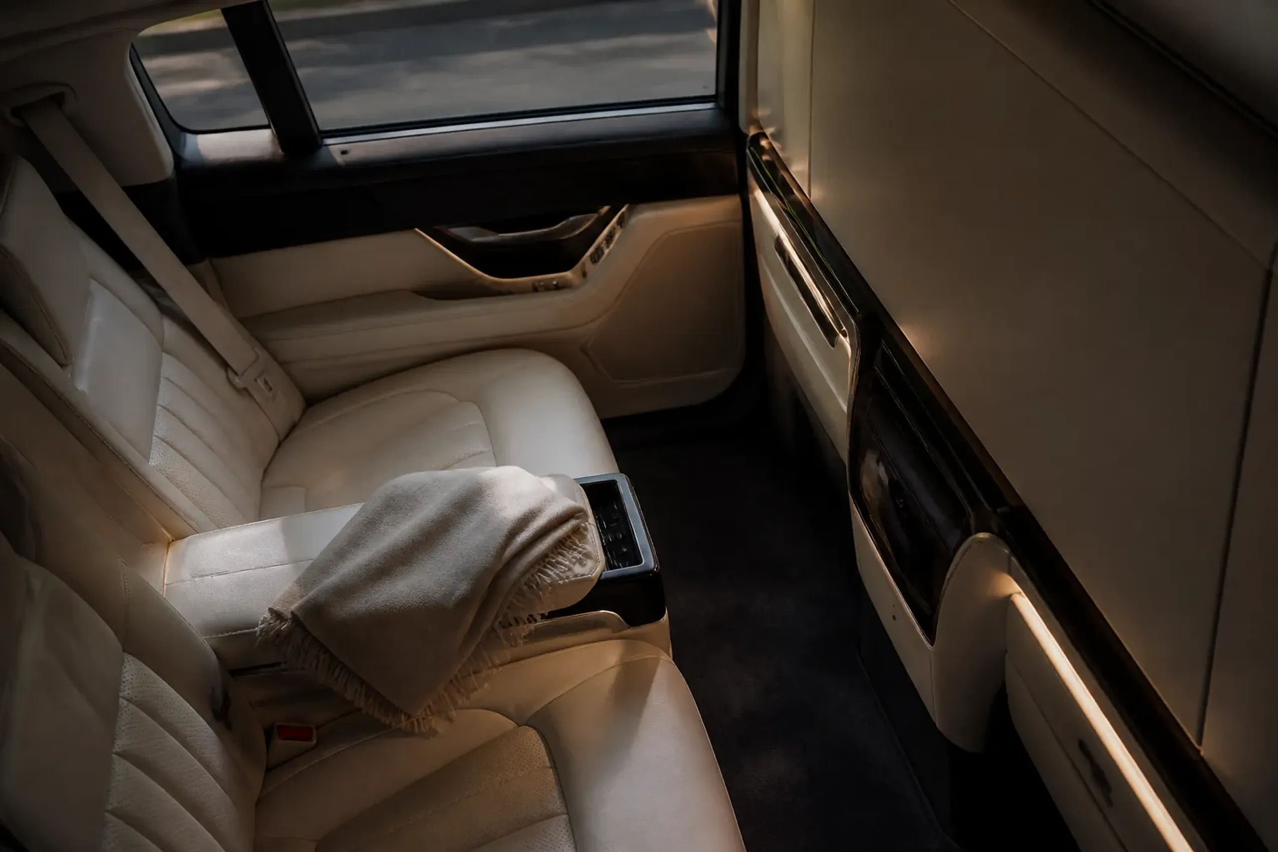 Executive minivan rear cabin with leather seats and privacy partition, representing discreet private transportation in Japan