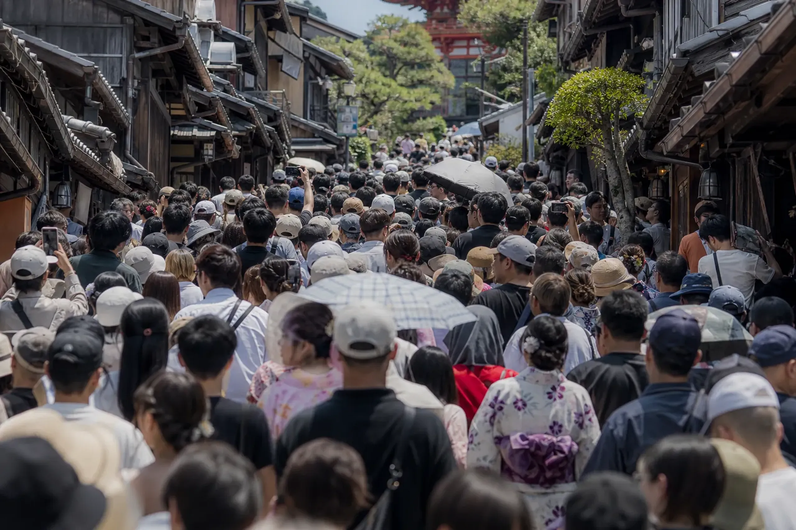 Crowded sloped approach to Kiyomizu-dera in Kyoto filled with visitors at midday