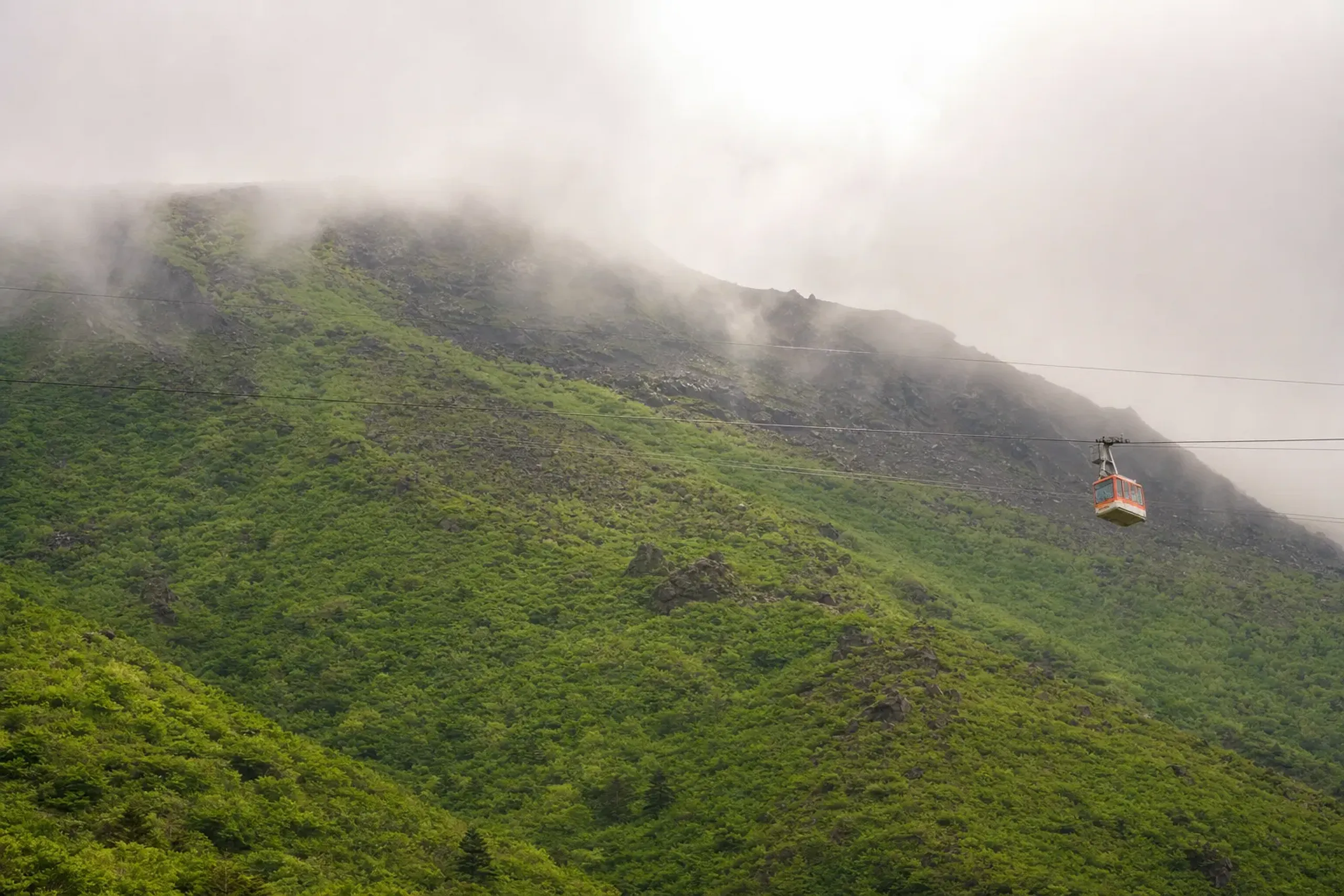 The Unzen Ropeway cable car ascending through fresh green slopes toward Mount Fugen in Unzen-Amakusa National Park
